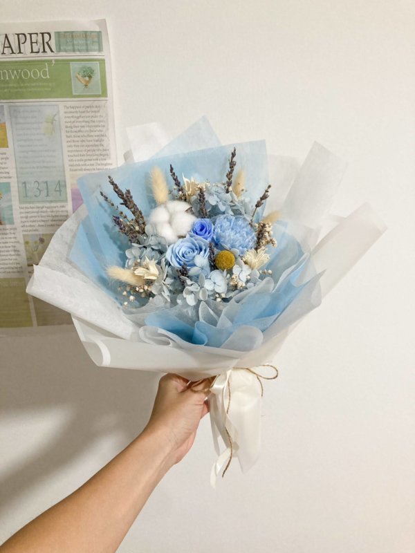 blue rose and carnation flower bouquet (wrapped in white)